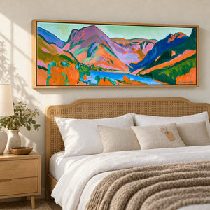 A panoramic Lake District canvas above a bed with a gift tag on the pillow