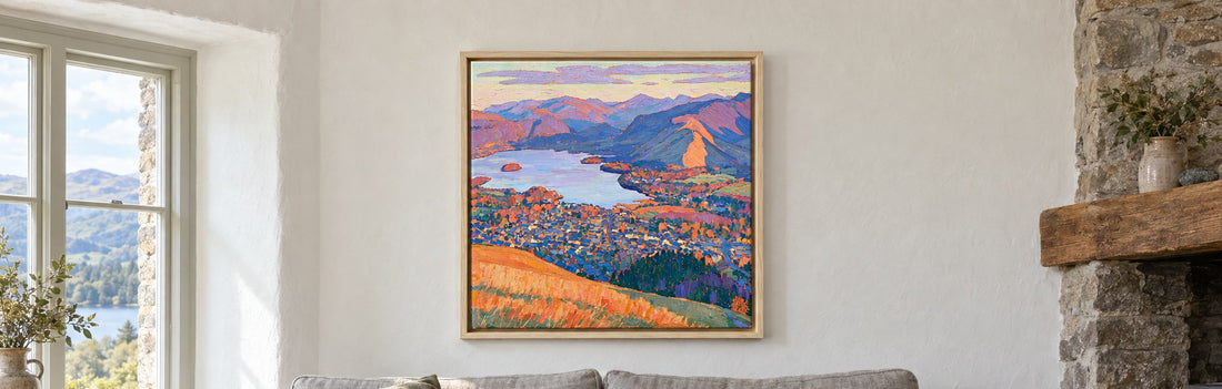 A framed canvas of Keswick and Derwentwater seen from Latrigg, hanging above a sofa in a Lake District cottage sitting room