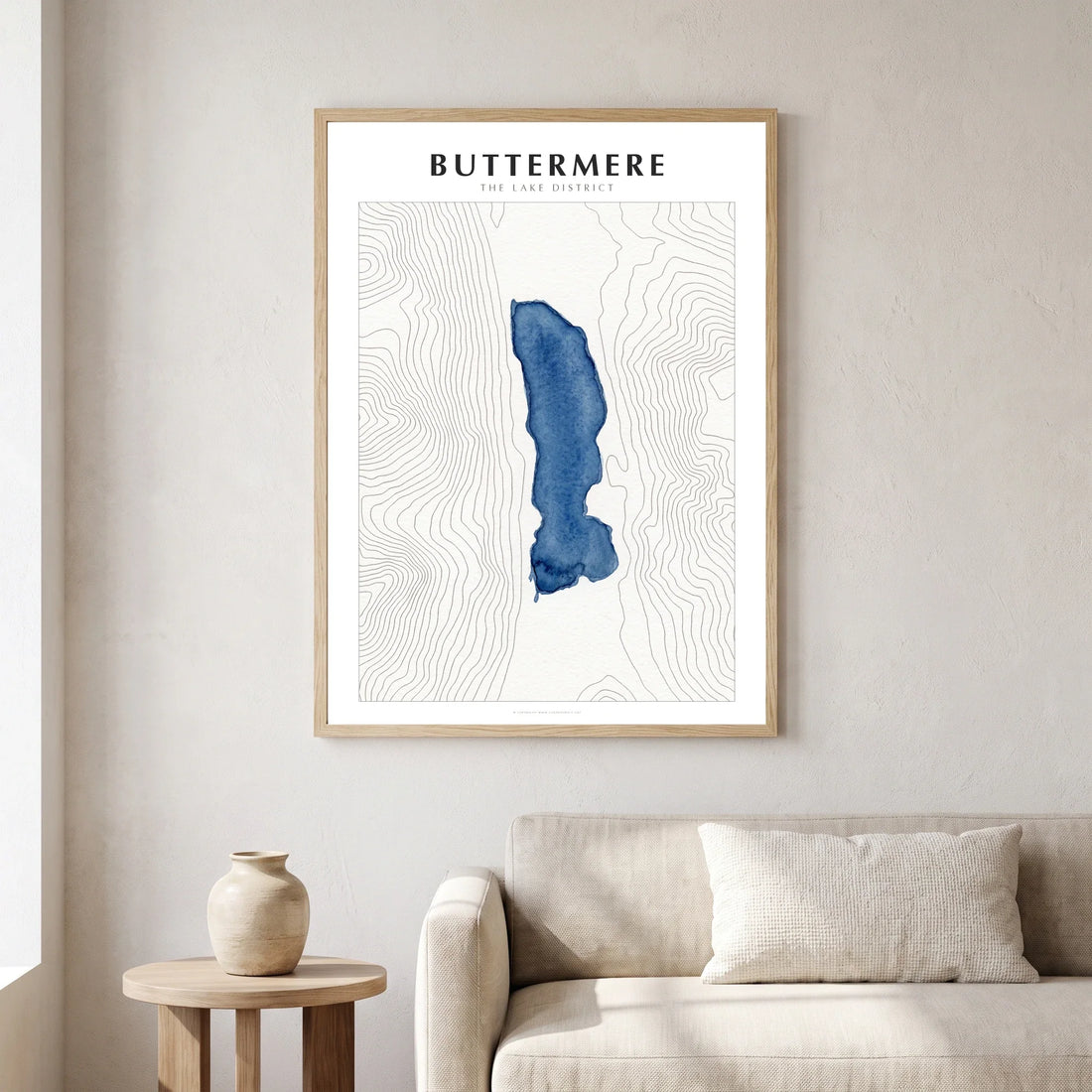 Buttermere watercolour map poster in a natural wood frame, hanging in a living room