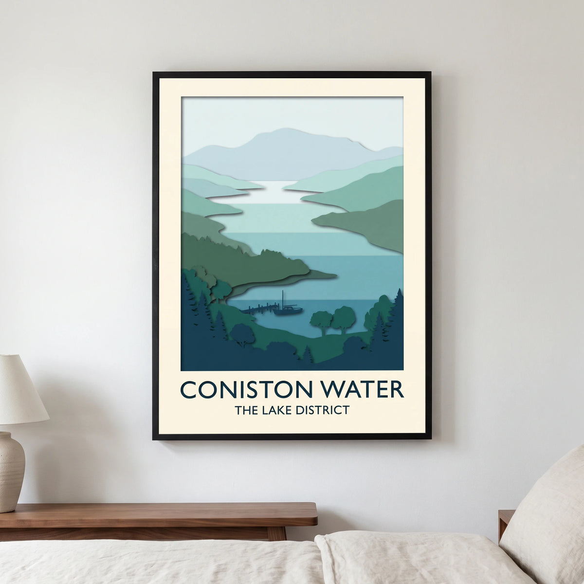 Coniston Water travel poster in a black frame, hanging in a bedroom3