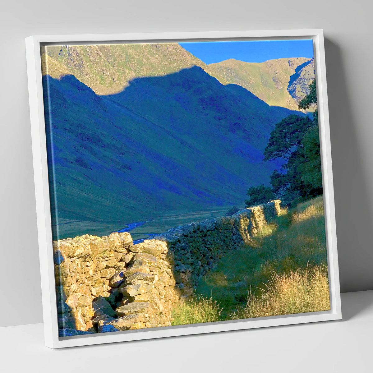 Sunlit Wall and Shadowed Fells lake district valley canvas wall art in white frame