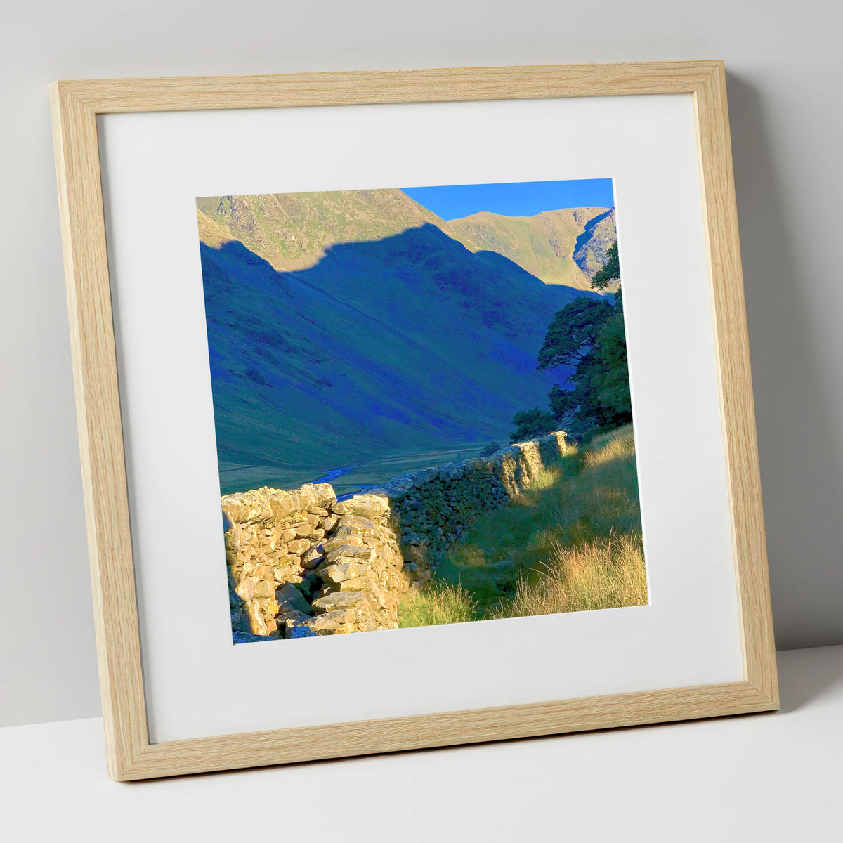 Sunlit Wall and Shadowed Fells lake district valley art print in natural frame