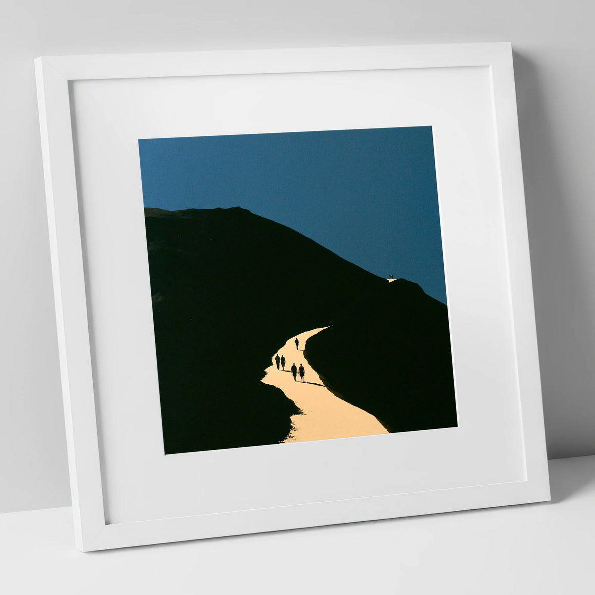 Walkers Ascending Luminous Fell Path lake district walking art print in white frame