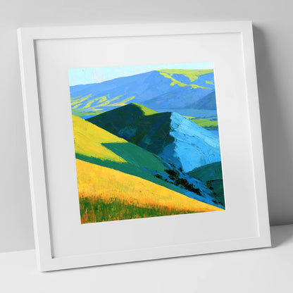 Vibrant Sunlit Fells and Deep Blue Shadows lake district sky art print in white frame