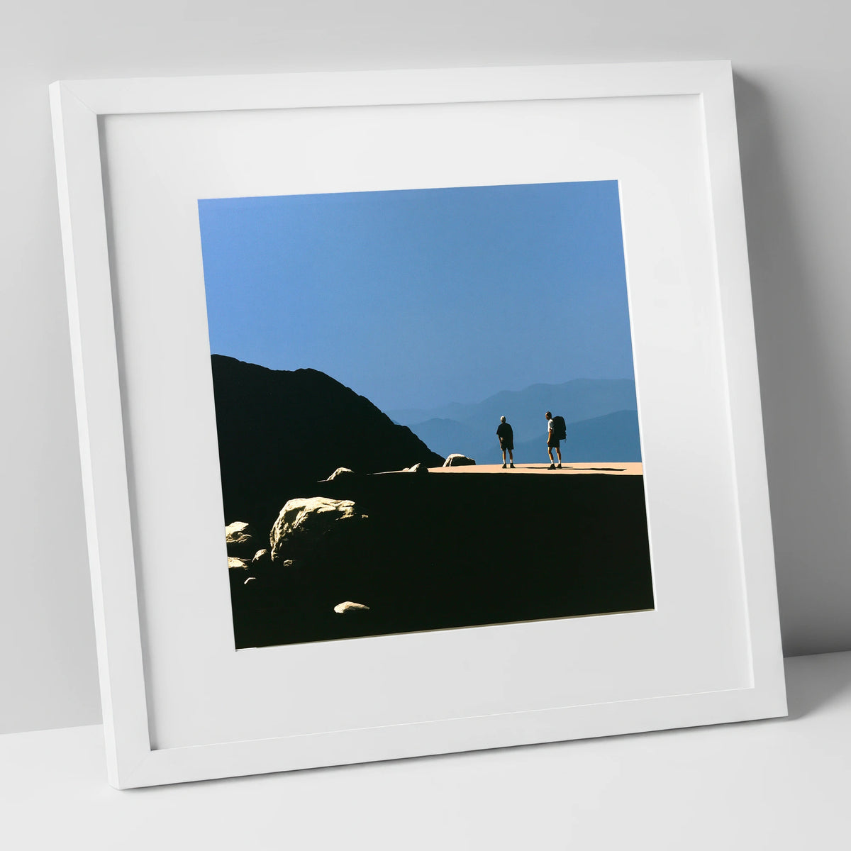 Hikers on a Sunlit Fell Ridge lake district fell art print in white frame