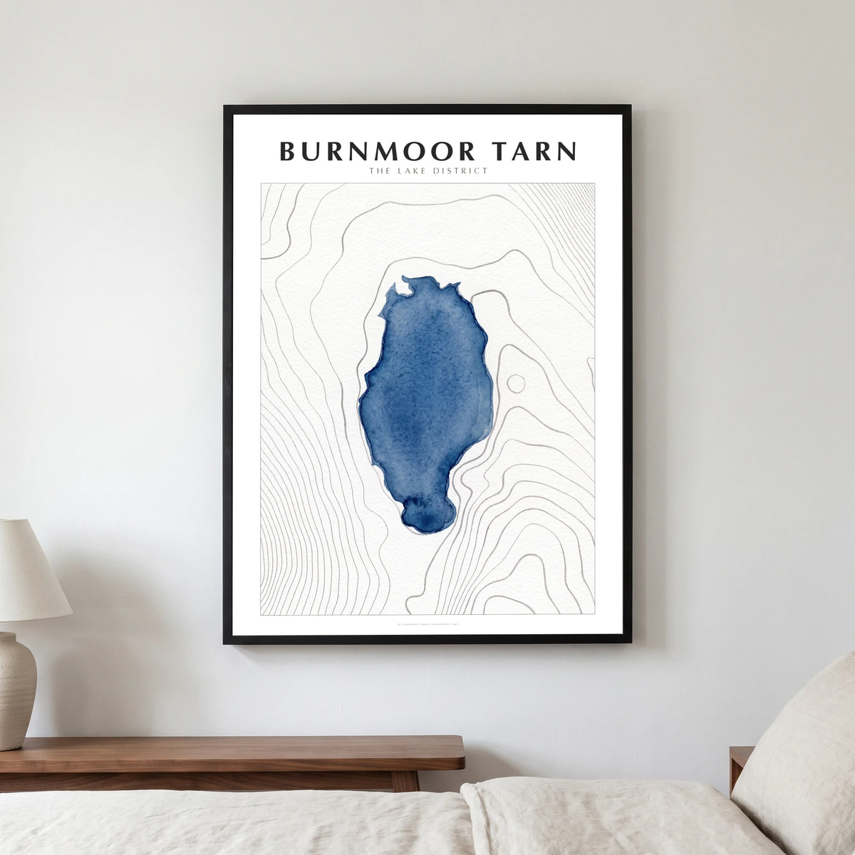 Burnmoor Tarn lake map poster in a black frame, hanging in a bedroom