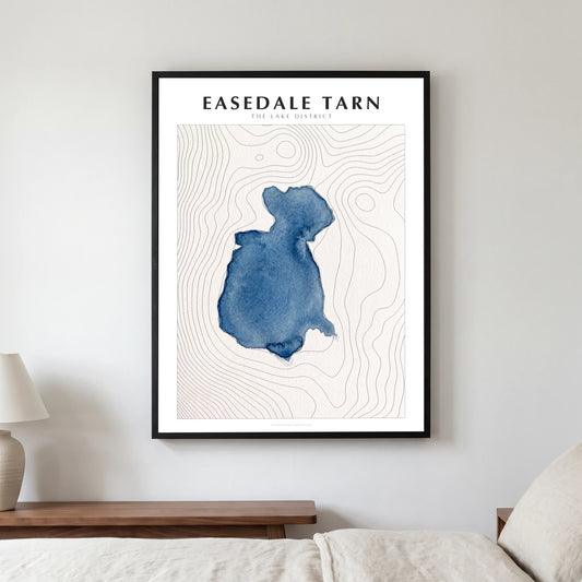 Easedale Tarn lake map poster in a black frame, hanging in a bedroom