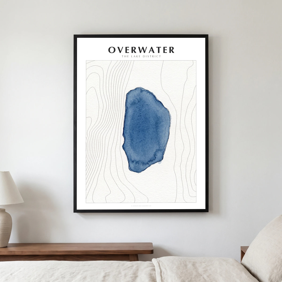 Overwater lake map poster in a black frame, hanging in a bedroom