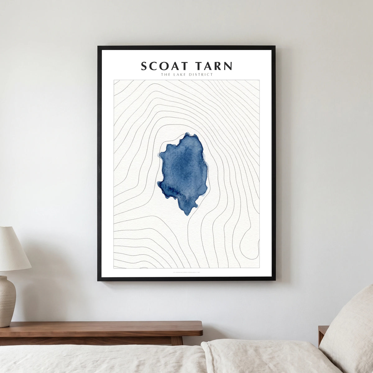 Scoat Tarn lake map poster in a black frame, hanging in a bedroom