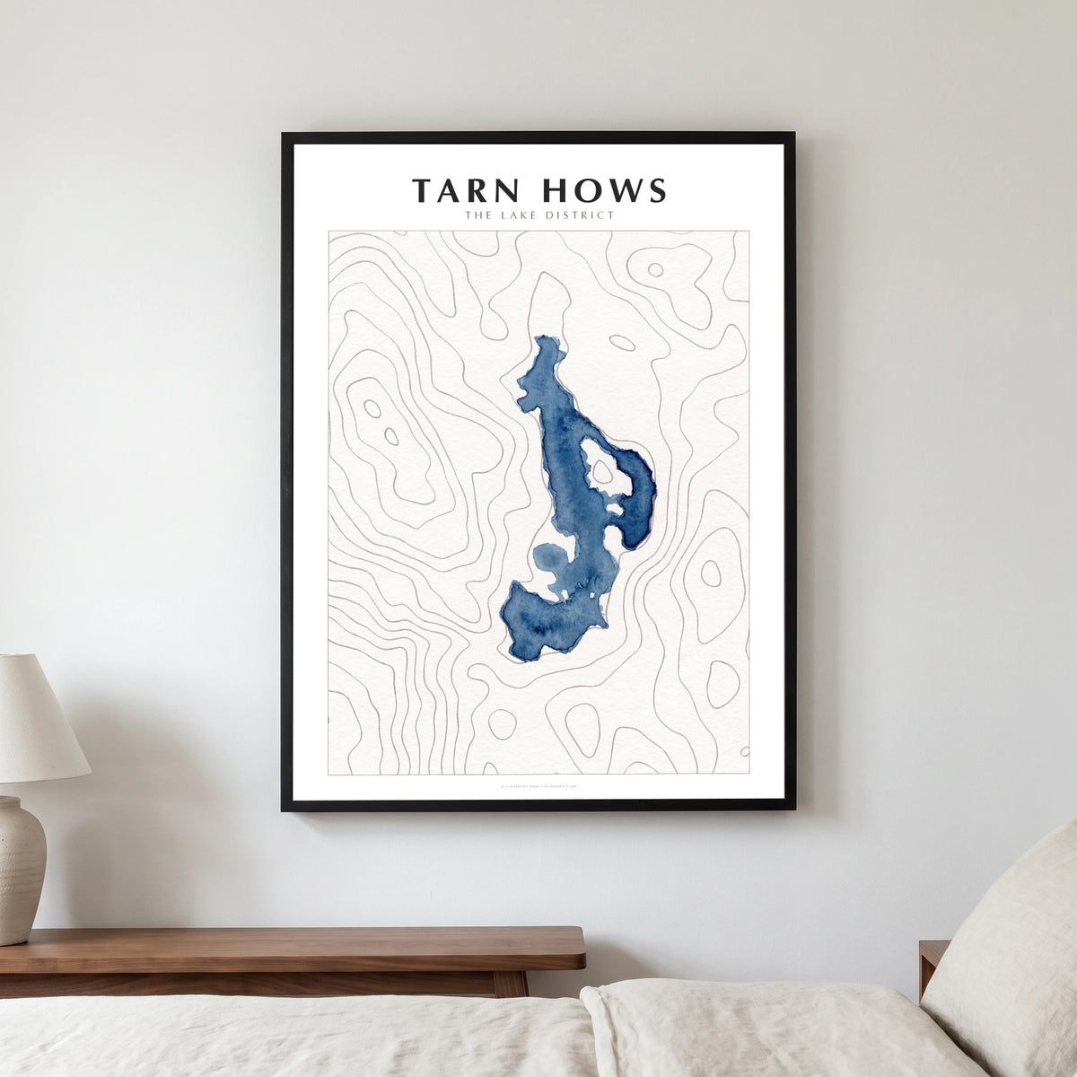 Tarn Hows lake map poster in a black frame, hanging in a bedroom