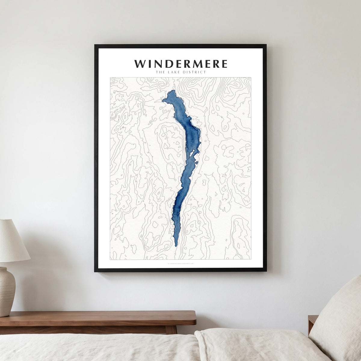 Windermere lake map poster in a black frame, hanging in a bedroom