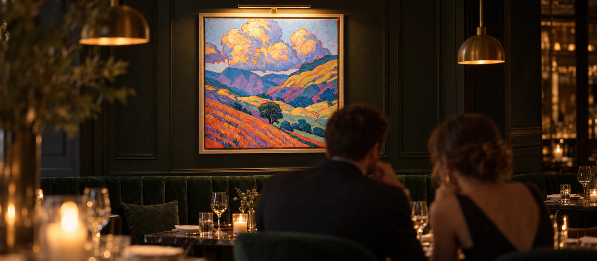 A couple dining beneath a lit Lake District painting in a restaurant in the evening